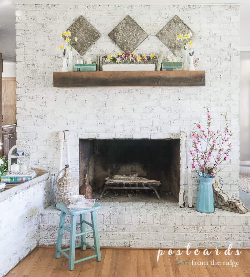white painted brick fireplace with spring decor