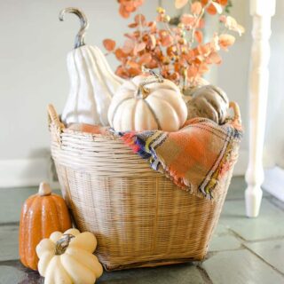 realistic faux pumpkins in woven basket