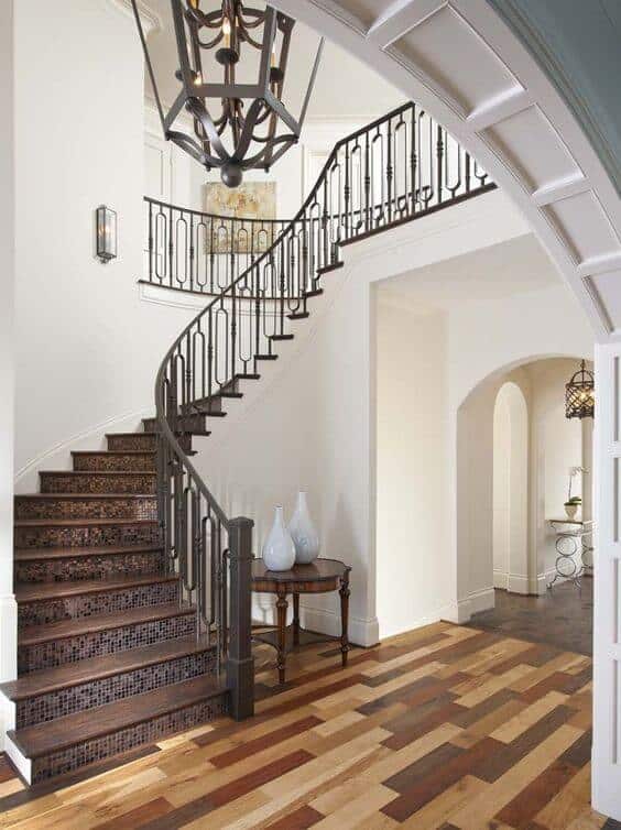 entry with wood floor and iron stair rail