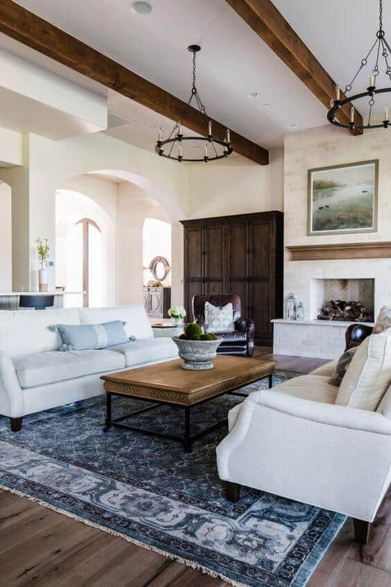 living room with wood beams and blue area rug