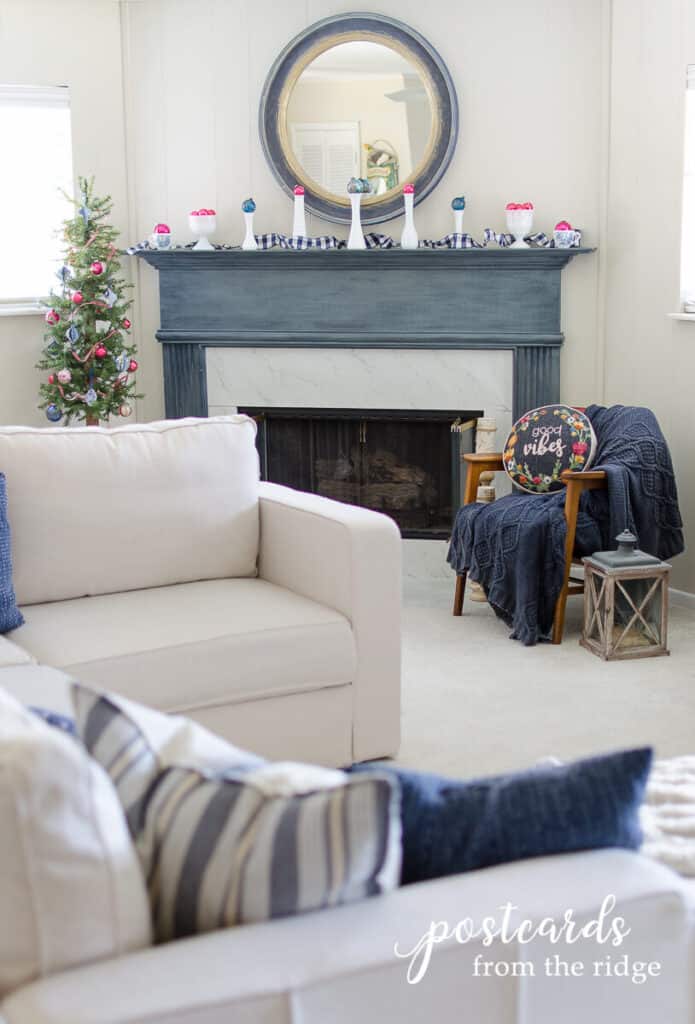 blue mantel decorated with vintage colorful glass ornaments on top of milk glass vases