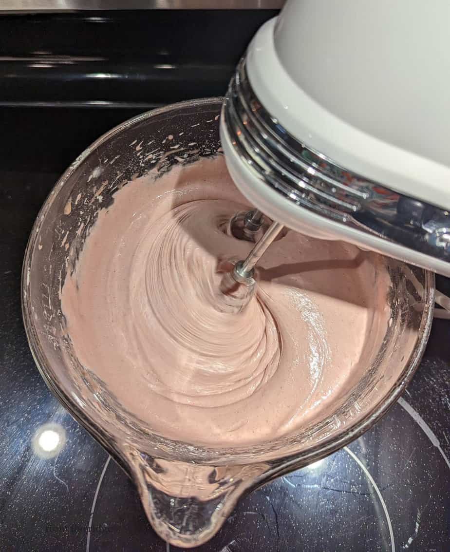 blackberry wine cake being mixed with hand mixer