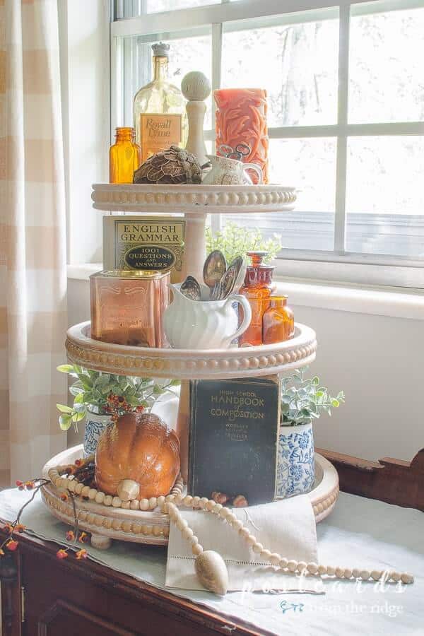 faux pumpkins and fall decor on tiered tray