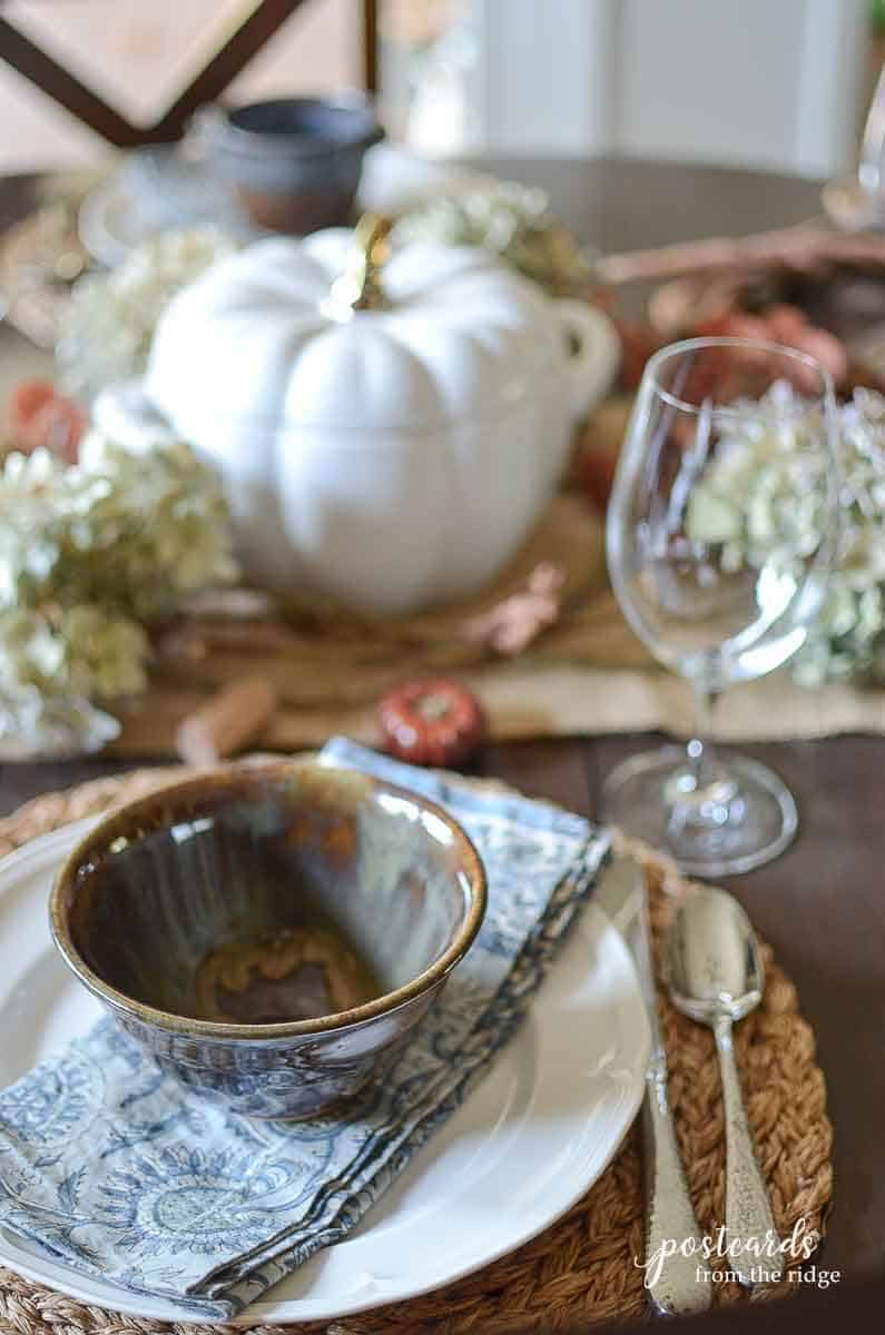 pottery bowl and white ceramic pumpkin place setting