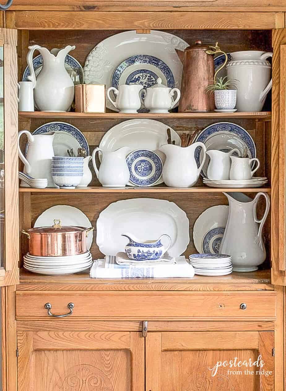 antique hutch with blue and white and copper