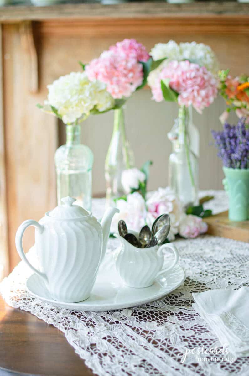 vintage platter with teapot and creamer on lace tablecloth